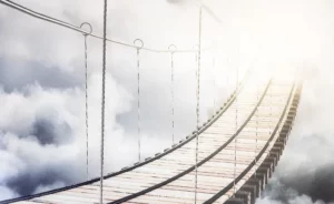 Pont de corde suspendu menant vers une lumière céleste dans les nuages.